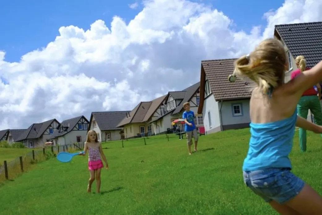 Kinderen spelen buiten bij de bungalows