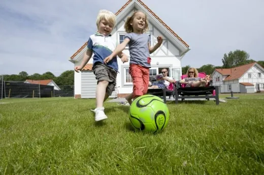 Kinderen spelen buiten in de omgeving van hun vil