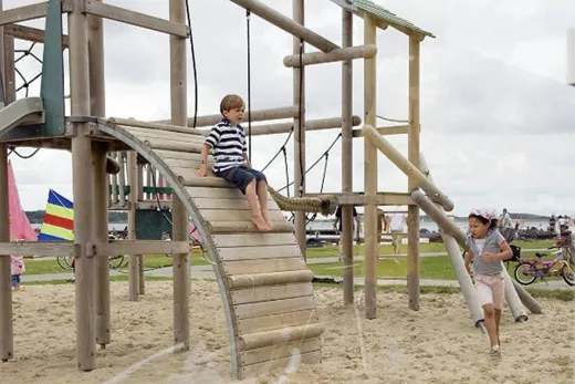 Kinderen spelen op 1 van de speeltoestellen