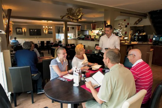Mensen eten in 1 van de restaurants op het park