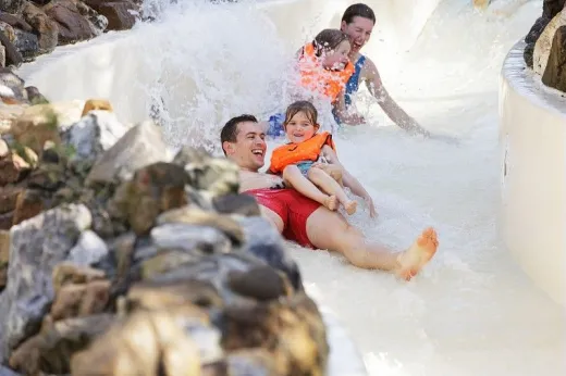 Gezin glijd in de wildwater baan 