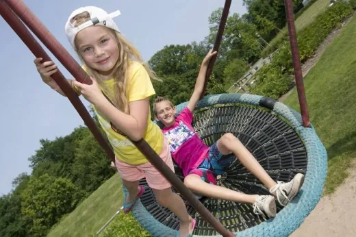 Kinderen schommelen in de speeltuin