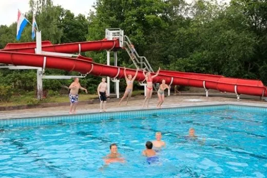 Het verwarmde buitenzwembad met glijbaan