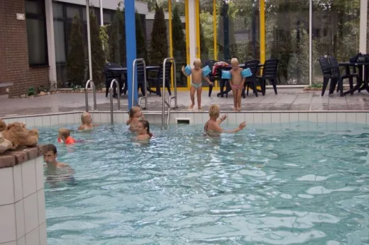 Kinderen zwemmen in het overdekte zwembad