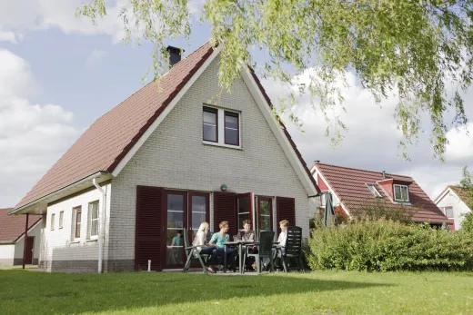 Familie zittend achter het huis