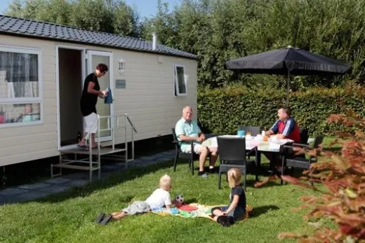 Mensen zitten buiten bij hun caravan