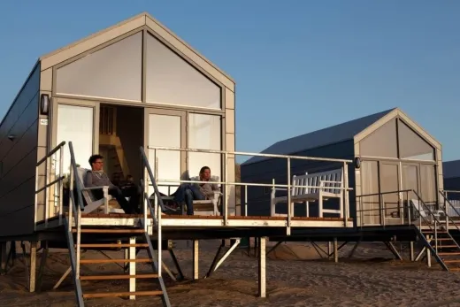 Mensen zitten op het terras bij hun eigen strandhuis