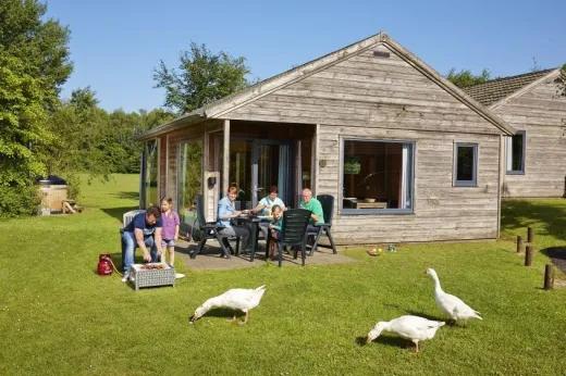 Mensen zitten op het terras bij hun eigen bungalow