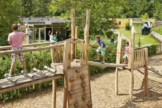 Kinderen spelen op de speeltoestellen in 1 van de speeltuinen 