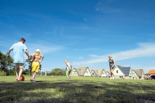 Kinderen voetballen dichtbij de villa's