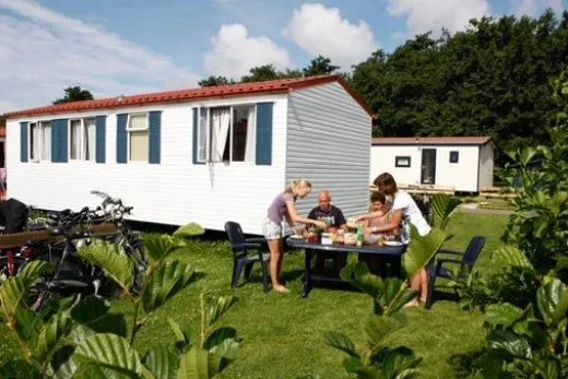 Mensen zitten buiten bij hun huurcaravan